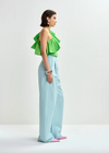 Side view of bright green top worn with blue trousers