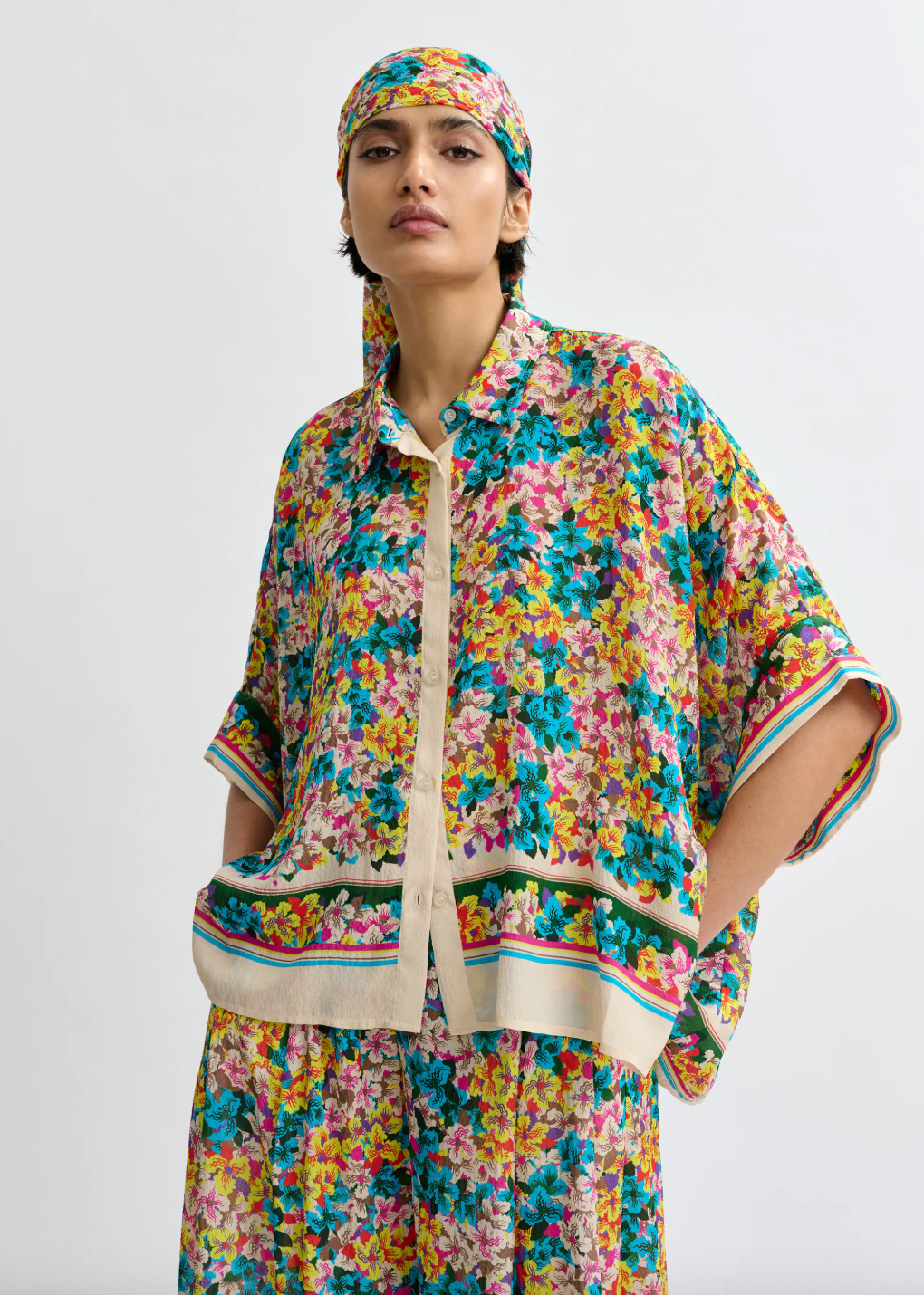 Floral blouse worn with matching trousers and head scarf