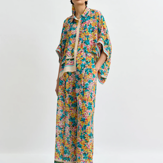 Woman wearing a colorful floral outfit on a white background