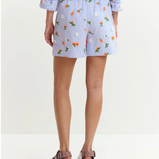 Person wearing a light blue floral outfit on a white background