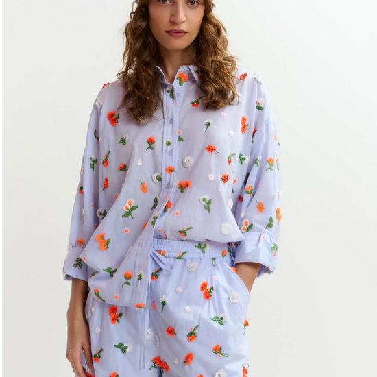 Woman wearing a floral outfit with a headscarf on a white background