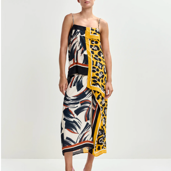 Woman wearing a colourful Skirt and top with a pattern on a white background