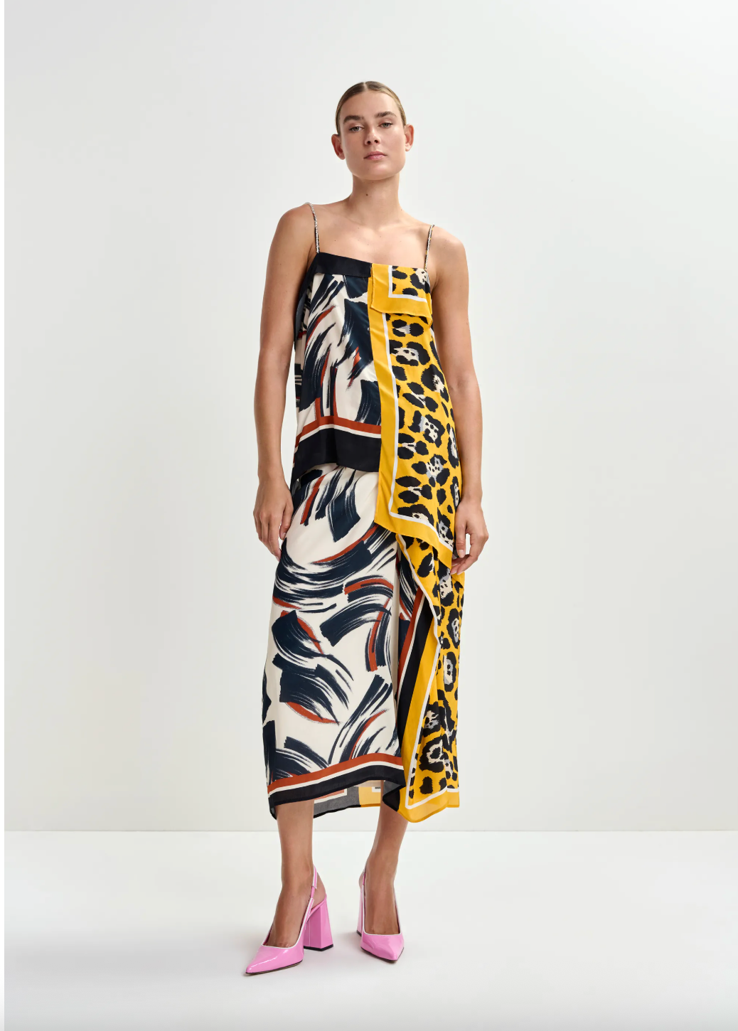 Woman wearing a colourful Skirt and top with a pattern on a white background