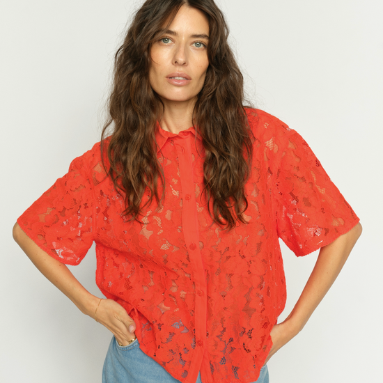 Model wearing orage lace shirt with pale wash denim