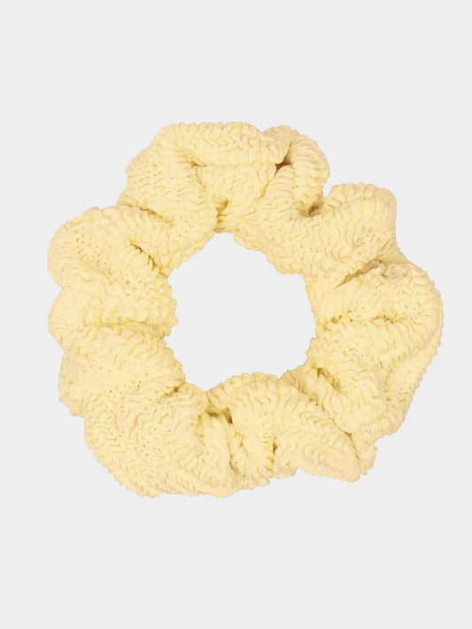 Yellow scrunchie on a light gray background