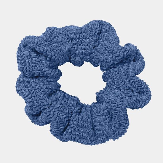 Blue textured scrunchie on a light gray background