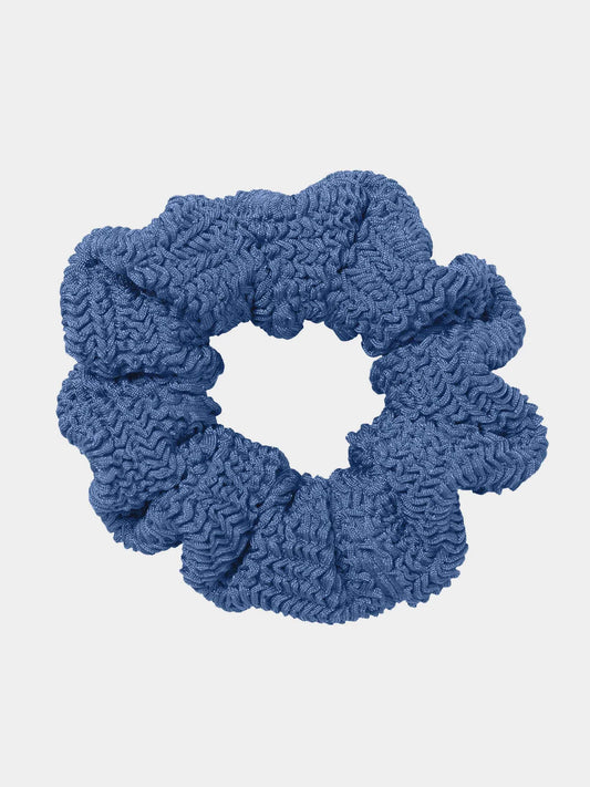 Blue textured scrunchie on a light gray background