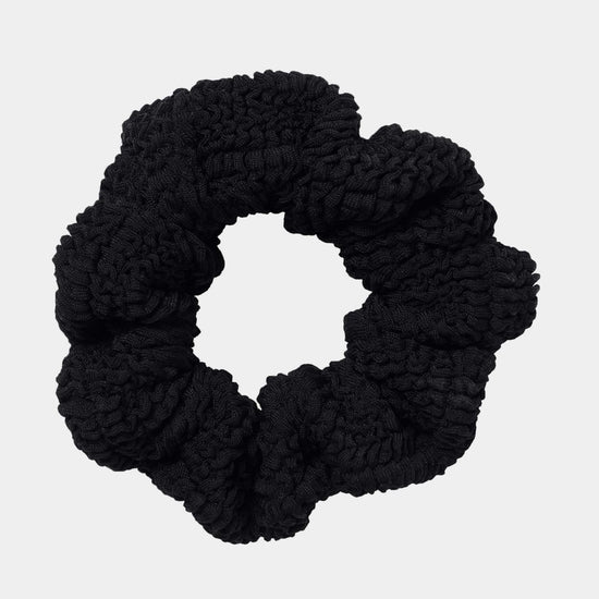 Black scrunchie on a light gray background