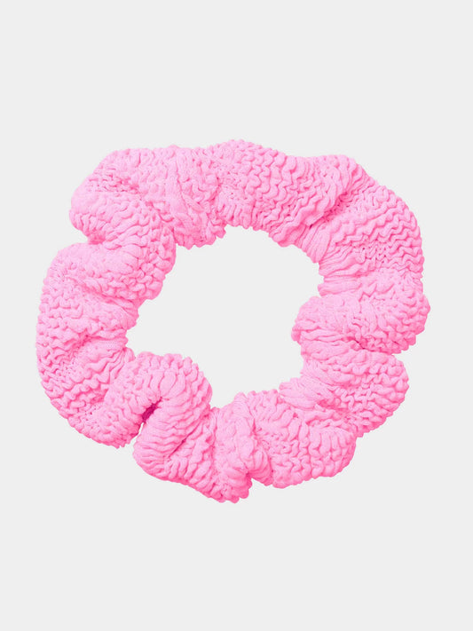 Pink textured scrunchie on a light pink background