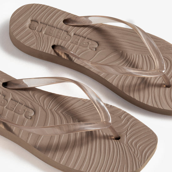 Pair of brown flip-flops on a white background birds eye view