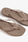 Pair of brown flip-flops on a white background birds eye view