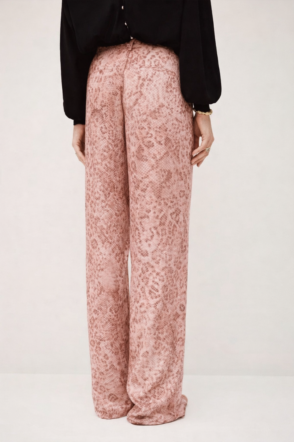 Rear view of pink animal print satin trousers with black knit from ba&sh