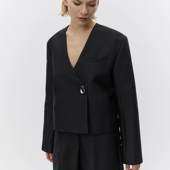 v neck black blazer with flared sleeves and single statement button from day birger close up