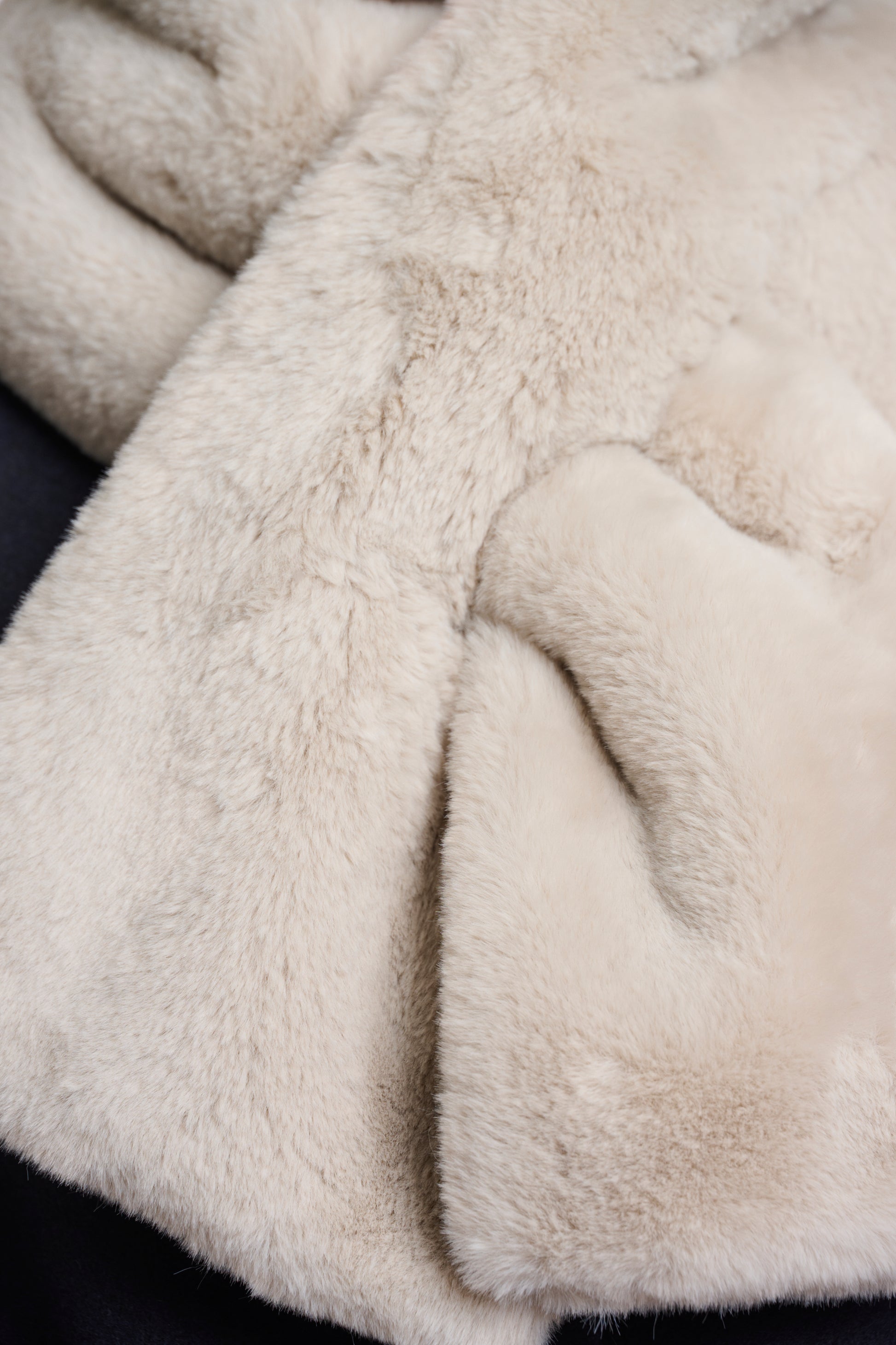 light beige long faux fur rectangular scarf with slit to enable to cross into itself close up