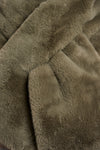green long faux fur rectangular scarf with slit to enable to cross into itself close up