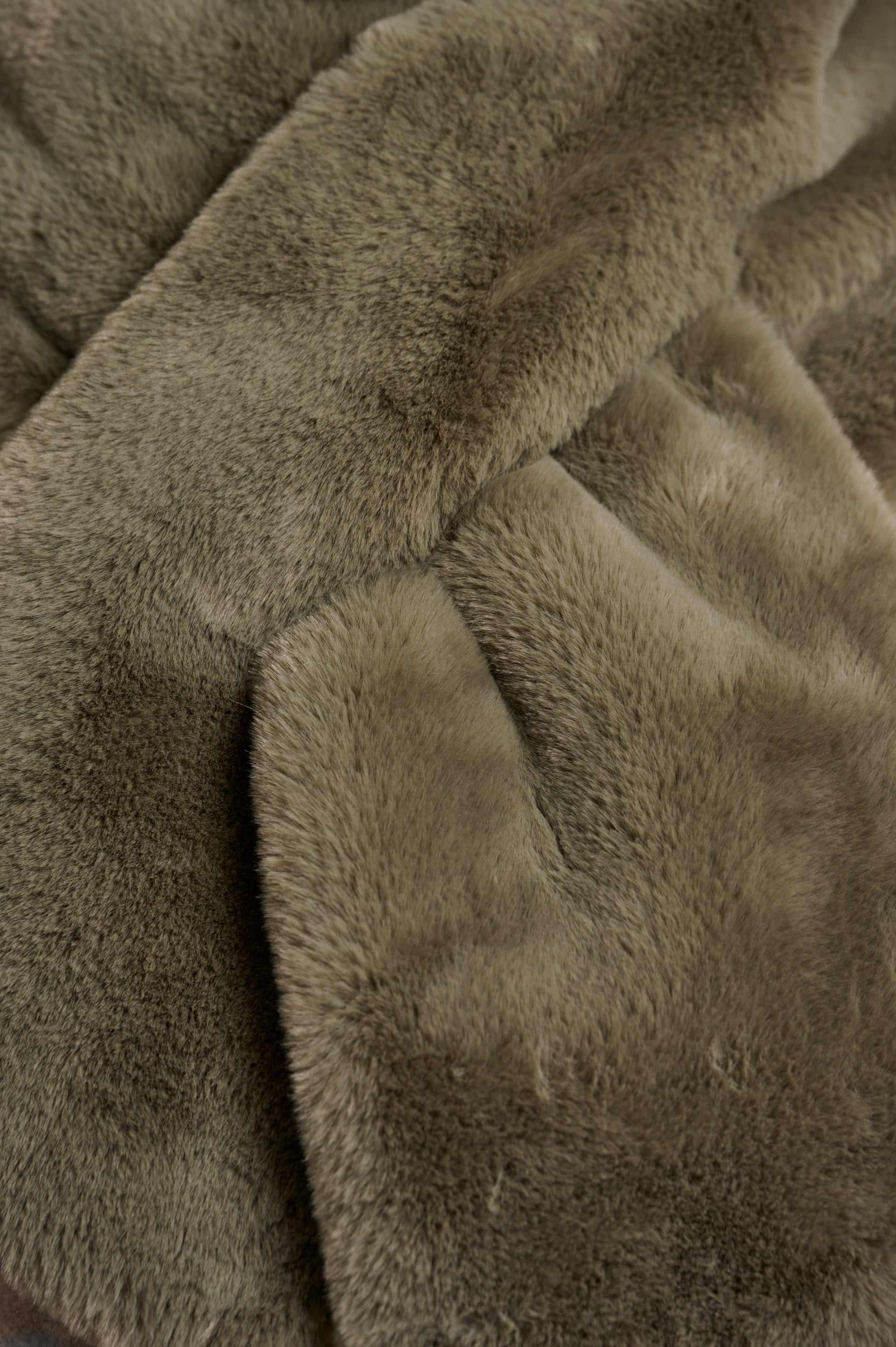 green long faux fur rectangular scarf with slit to enable to cross into itself close up