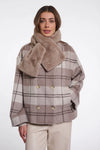 Woman wearing a plaid coat with a fur collar on a white background