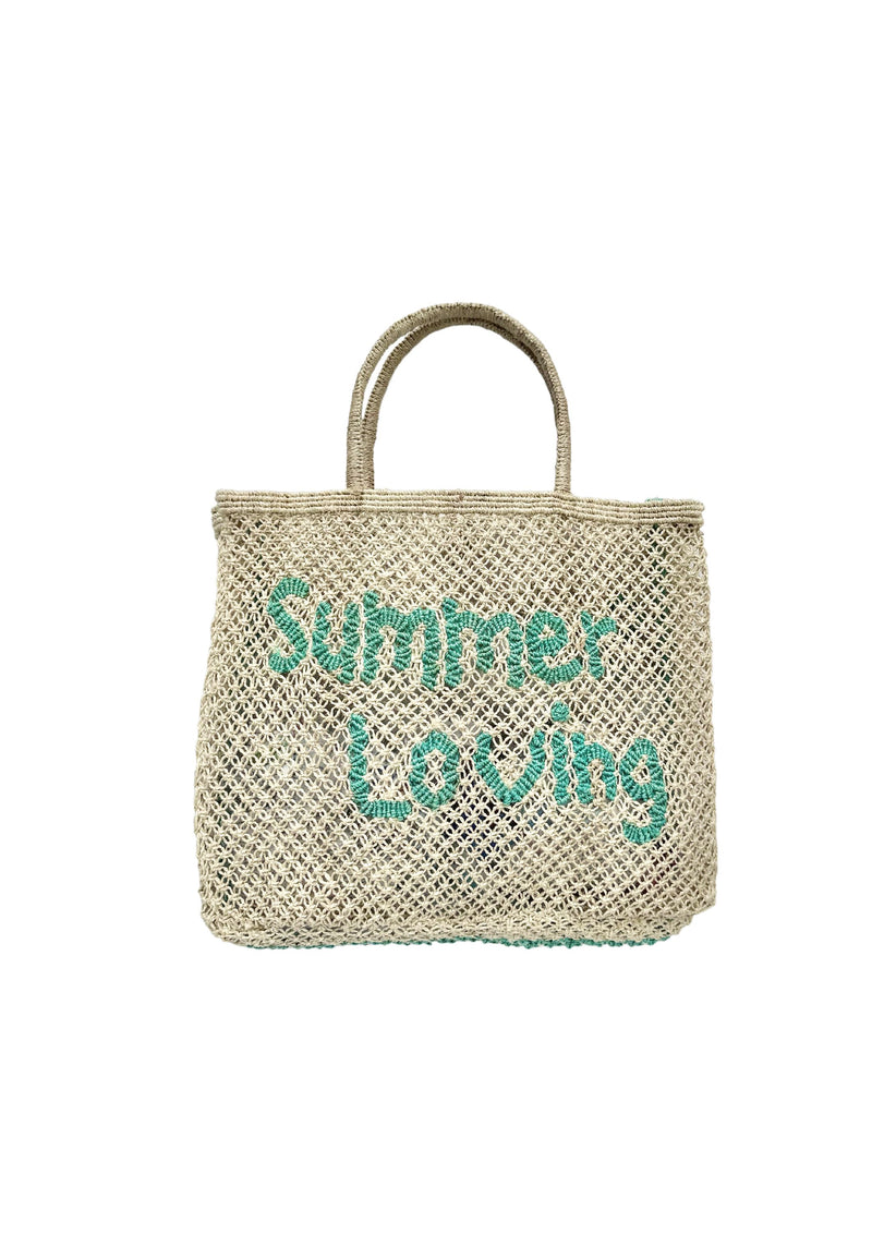 Neautral woven bag with blue writing saying 'summer loving' on