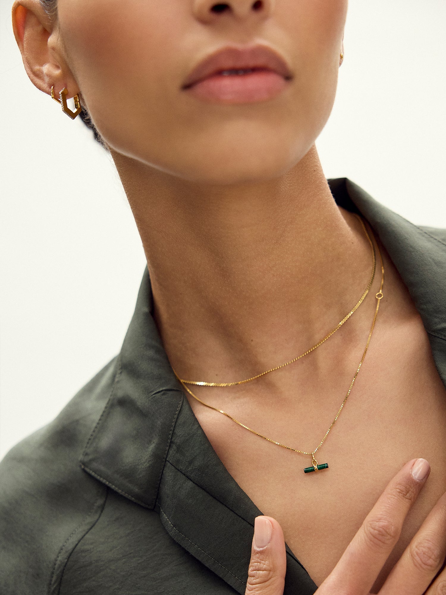 malachite rectangular pendant on a delicate gold chain and a gold ring from rachel jackson model shot