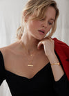gold t bar necklace with a circular ring and a delicate gold chain from rachel jackson model shot