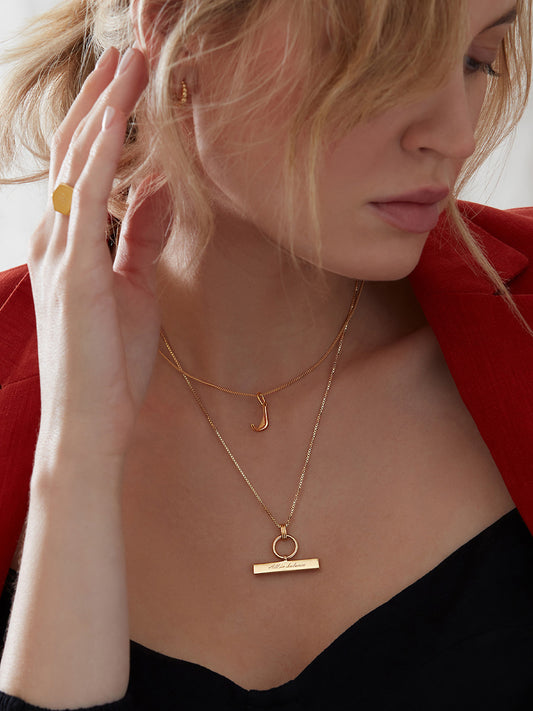 gold t bar necklace with a circular ring and a delicate gold chain from rachel jackson model shot