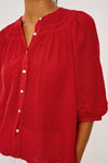 Red blouse with button details on a white background