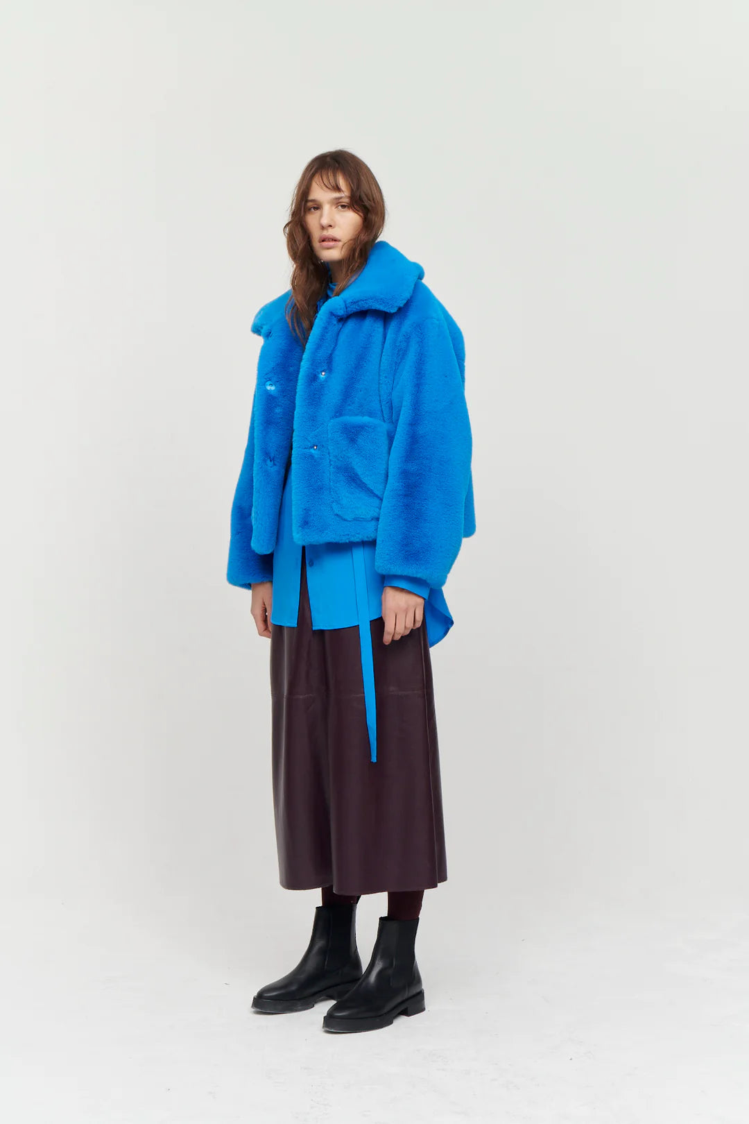 Bright blue boxy faux fur jacket with large collar and two front patch pockets