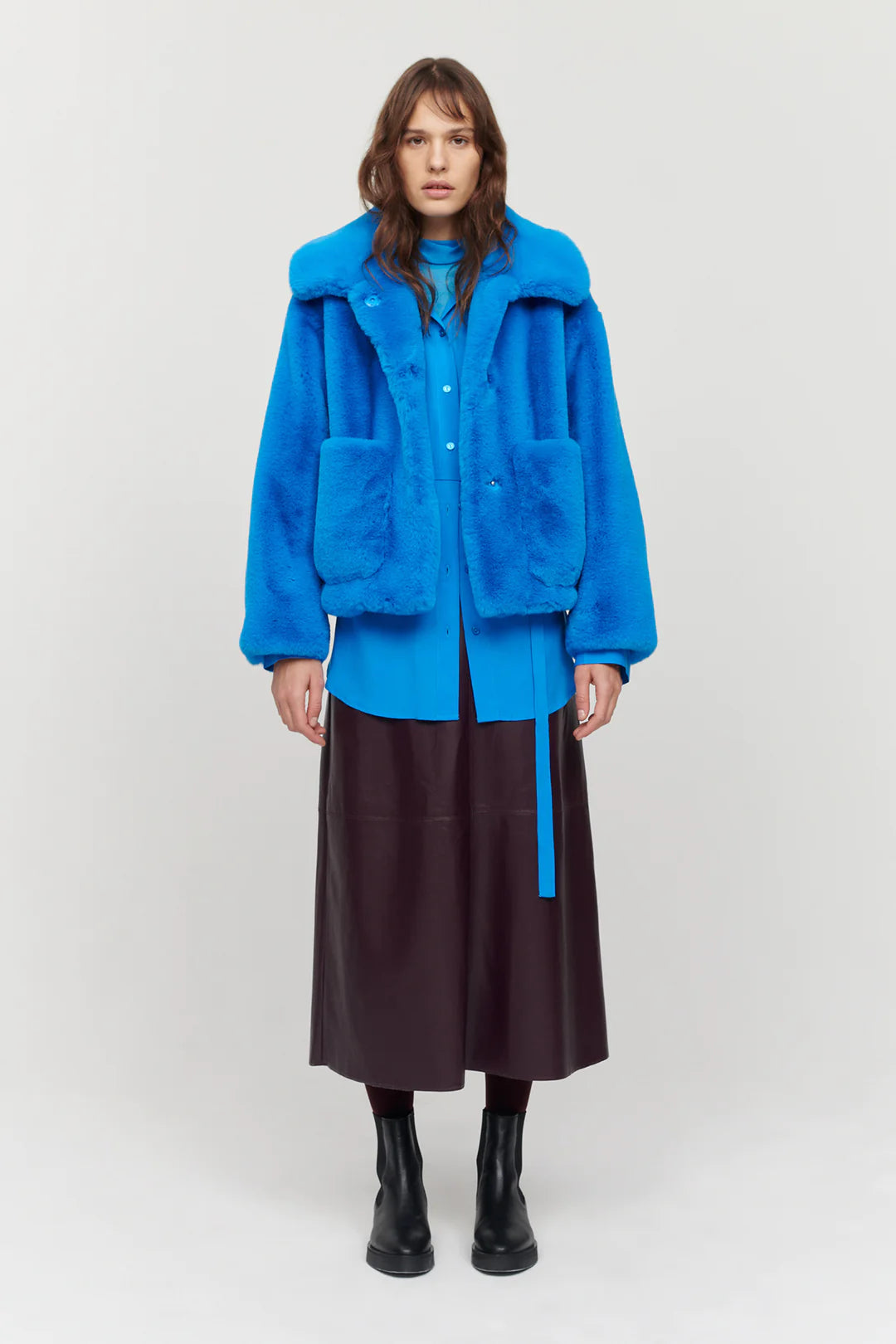 Bright blue boxy faux fur jacket with large collar and two front patch pockets