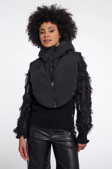 Woman wearing a black vest with sheer sleeves on a white background
