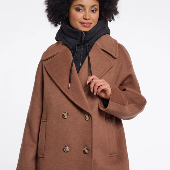 Woman wearing a brown coat with gold buttons on a white background