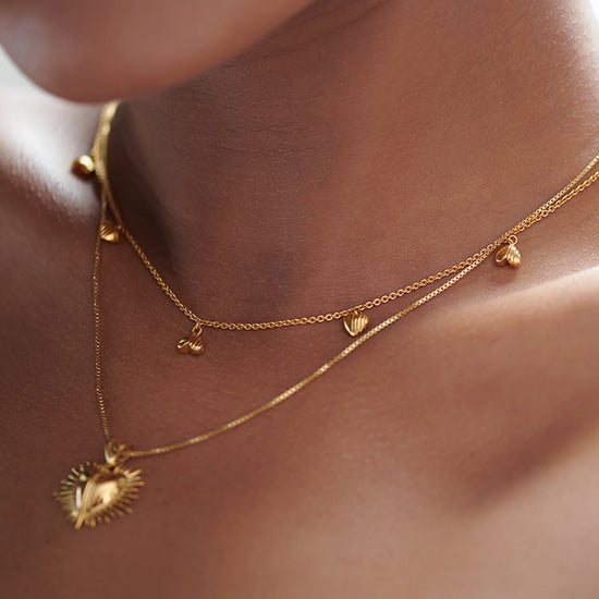 gold necklace with gold heart charms with a lobster clasp from rachel jackson model shot
