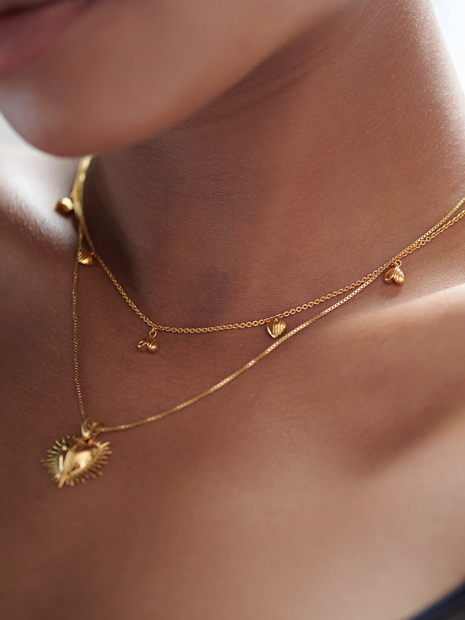gold necklace with gold heart charms with a lobster clasp from rachel jackson model shot
