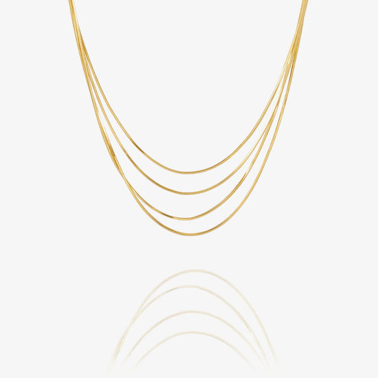 A delicate multi-strand gold chain necklace with five parallel strands, displayed against a clean white background with a soft reflection below.