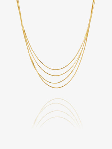 A delicate multi-strand gold chain necklace with five parallel strands, displayed against a clean white background with a soft reflection below.