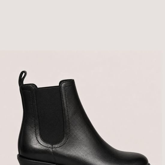 black chelsea boots on a side view on a plain white background 