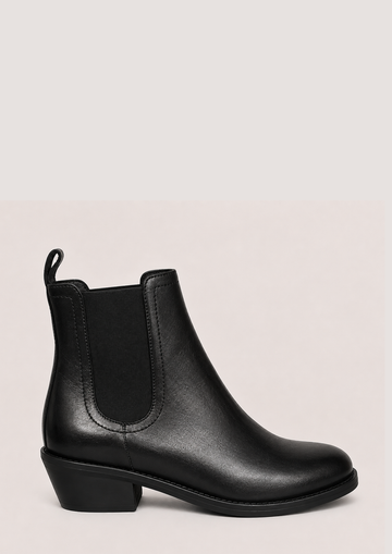 black chelsea boots on a side view on a plain white background 