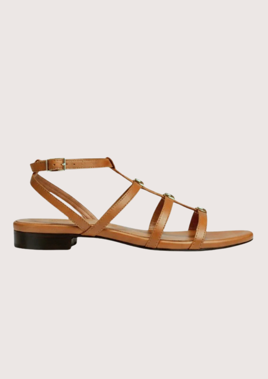 Tan sandal with thin straps on a light beige background
