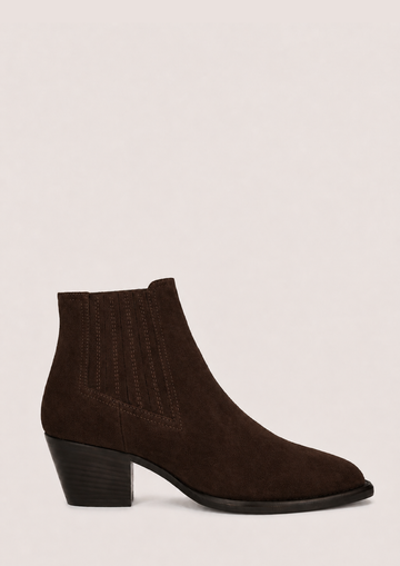 A dark brown suede ankle boot with a low block heel and pointed toe, shown from a side profile against a light beige background.