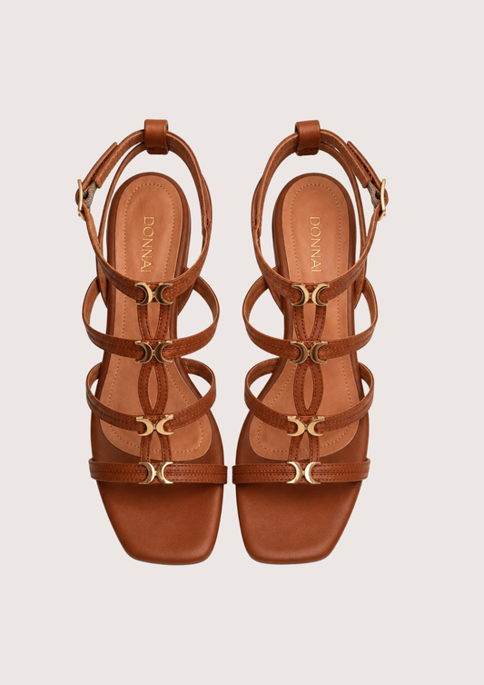 Pair of brown strappy sandals on a light beige background