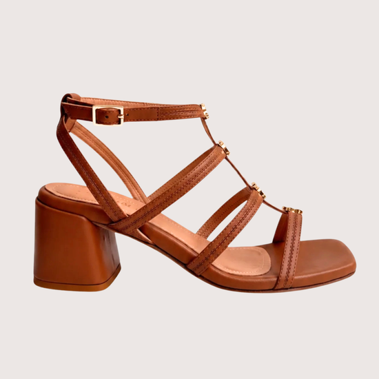 Tan leather healed sandal with gold hardware on a white background