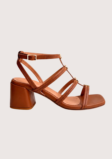 Tan leather healed sandal with gold hardware on a white background