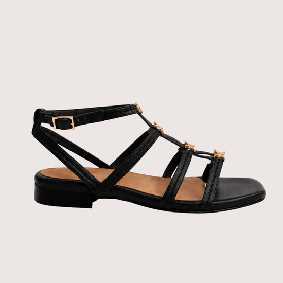 Black sandal with gold hard ware on a white background