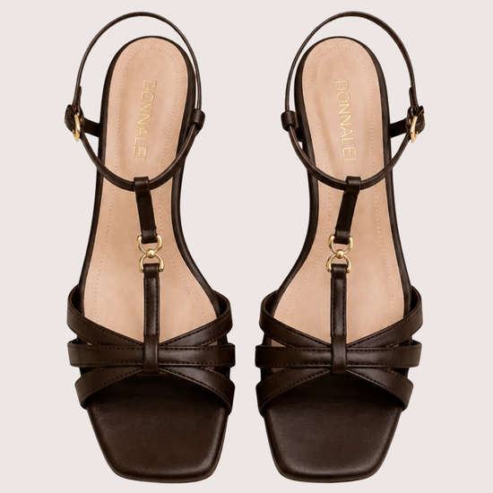Pair of brown strappy sandals on a light beige background