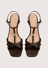 Pair of brown strappy sandals on a light beige background