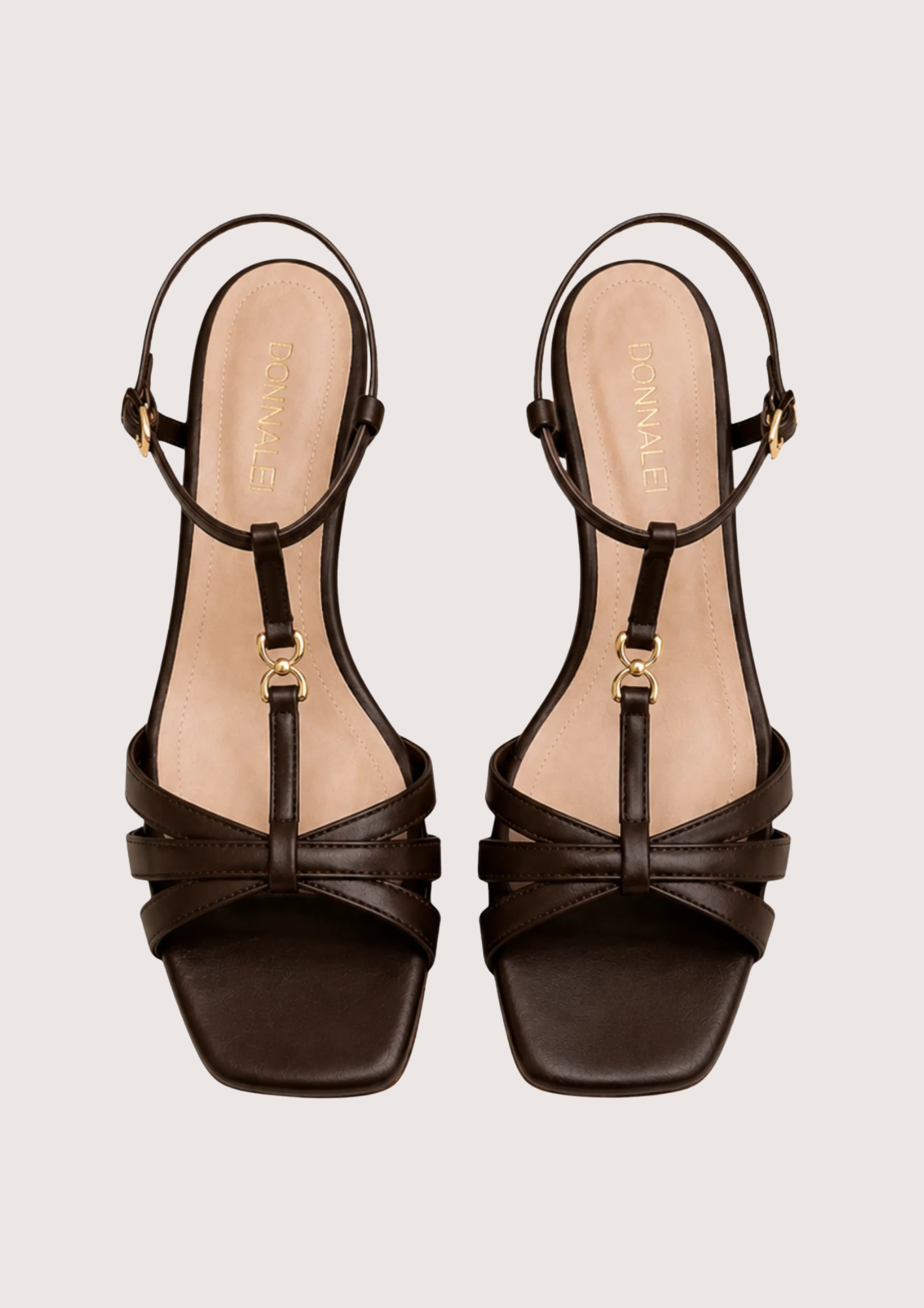 Pair of brown strappy sandals on a light beige background
