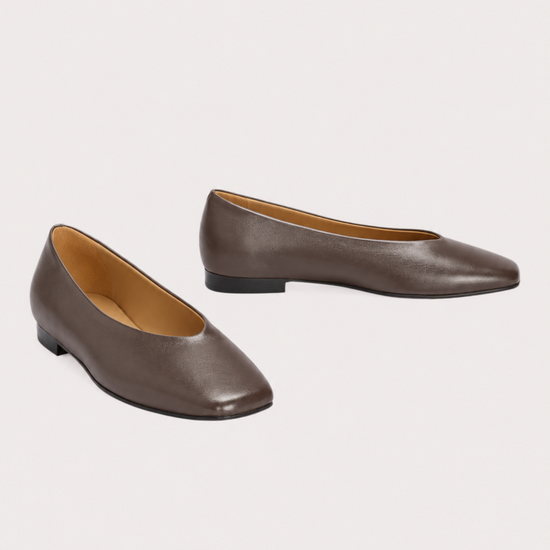 A pair of women's pointed-toe flats in smooth taupe-brown leather, displayed on a light gray background.