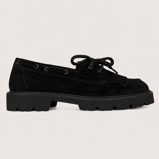 flat lay image of a chunky black suede loafer on a white background