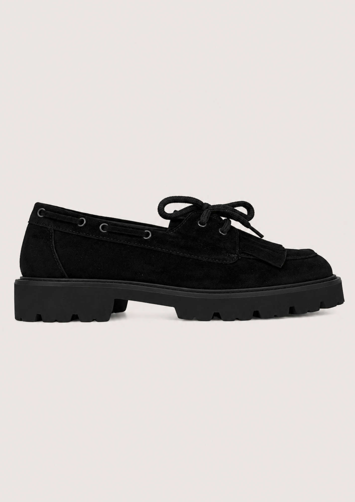 flat lay image of a chunky black suede loafer on a white background
