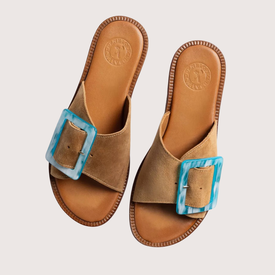 Brown sandals with a blue buckle on a light gray background