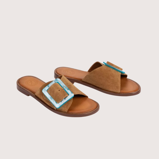 Tan suede sliders with a turquoise buckle detail